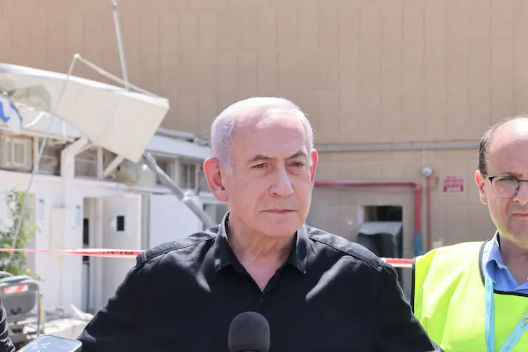 Israeli prime minister Benjamin Netanyahu dressed in a black open-necked shirt.