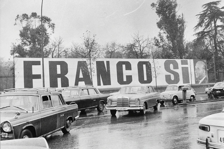 Foto en blanco y negro donde aparece un extenso cartel en el que puede leerse "Franco sí"