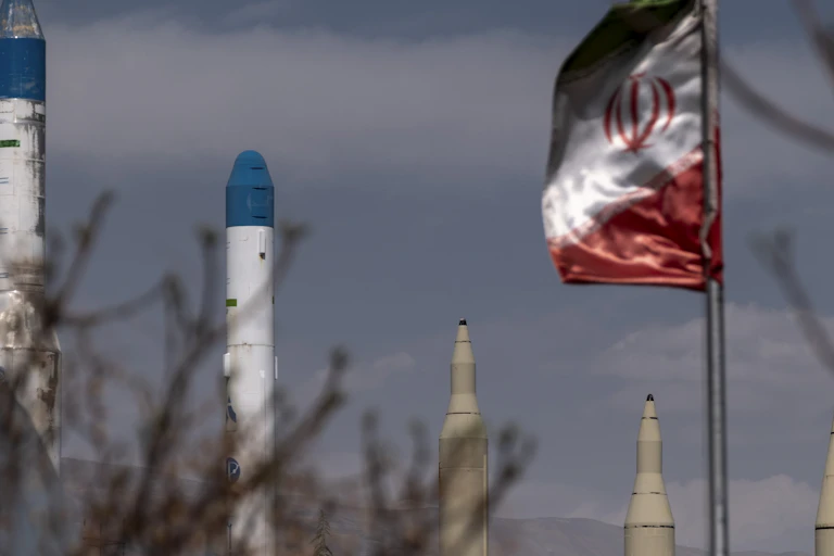 Missile warheads are seen next to a red, white and green flag.