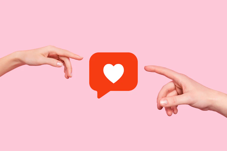 Two fingers reaching out towards a heart icon, against a light pink background