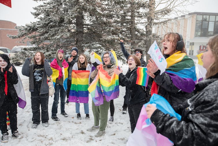 Jóvenes al aire libre en la nieve con arco iris.