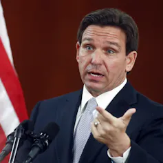 A man in a suit gesturing.