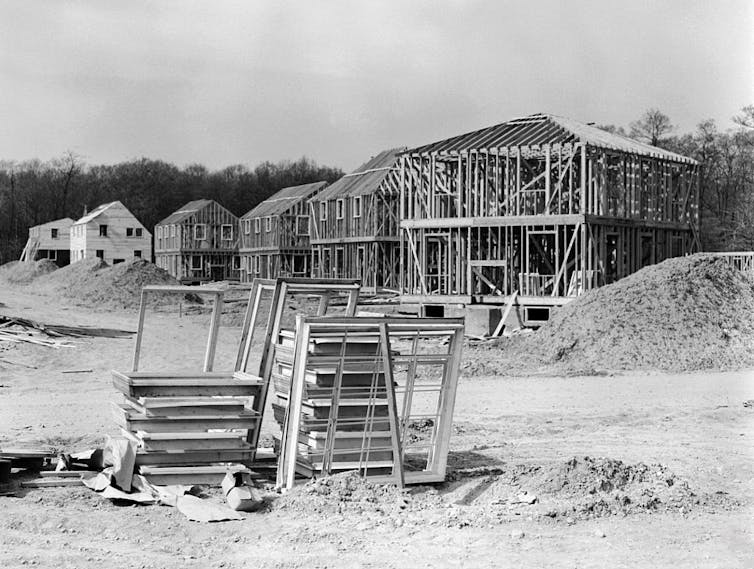 A row of half-constructed homes surrounded by piles of dirt.