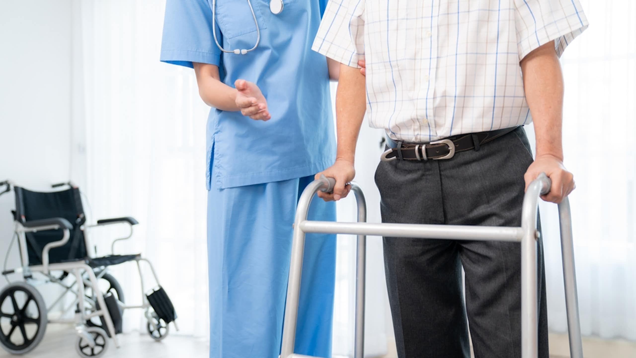 professionnel de la santé accompagne une personne en marchette