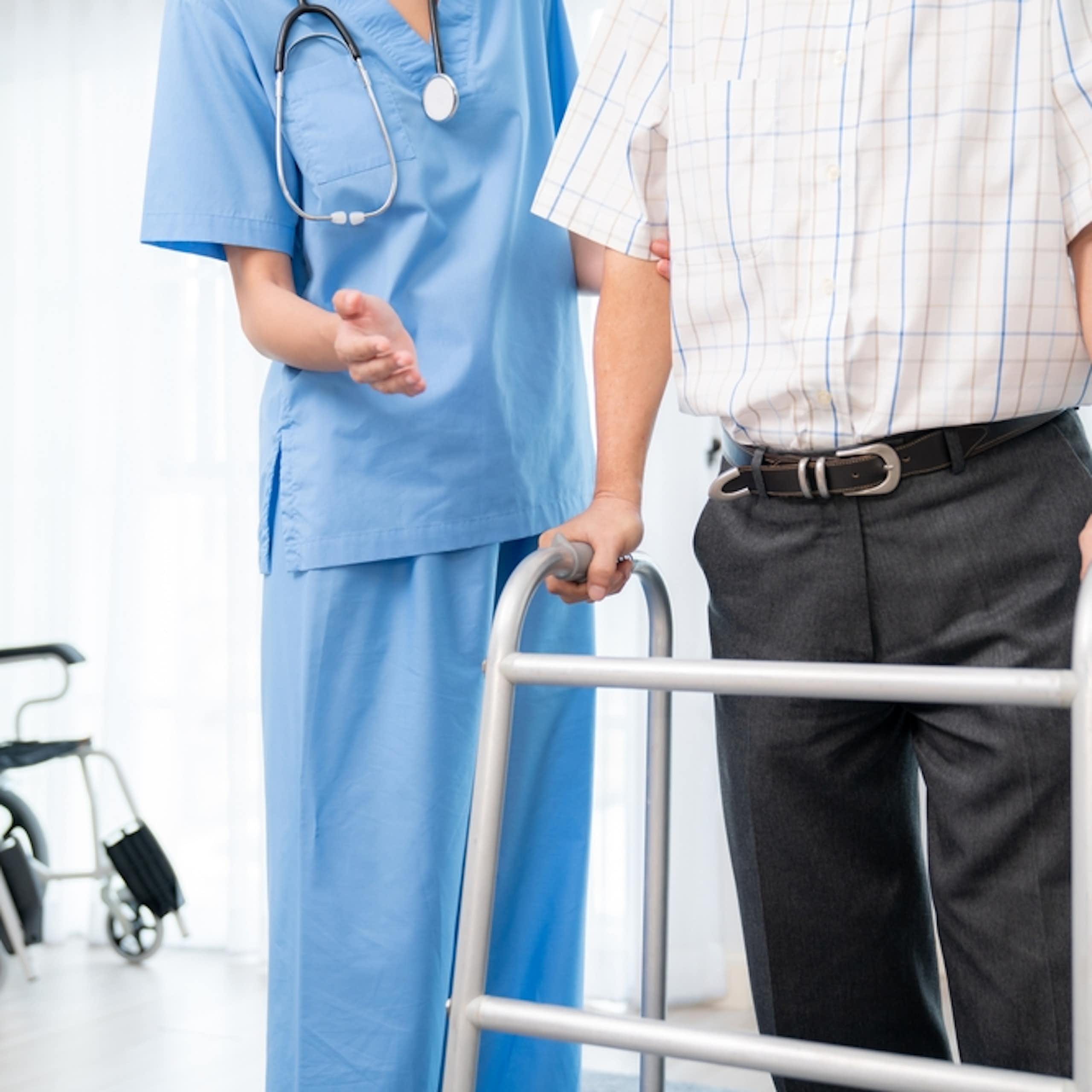 professionnel de la santé accompagne une personne en marchette