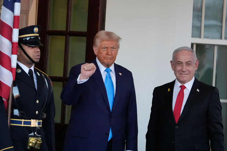 US president, Donald Trump, mmakes a clenched fist salute as he stands with the Israeli prime minister, Benjamin Netanyahu, outside the White House in February 2025.