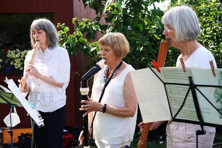 trois femmes âgées jouent divers instruments de musique