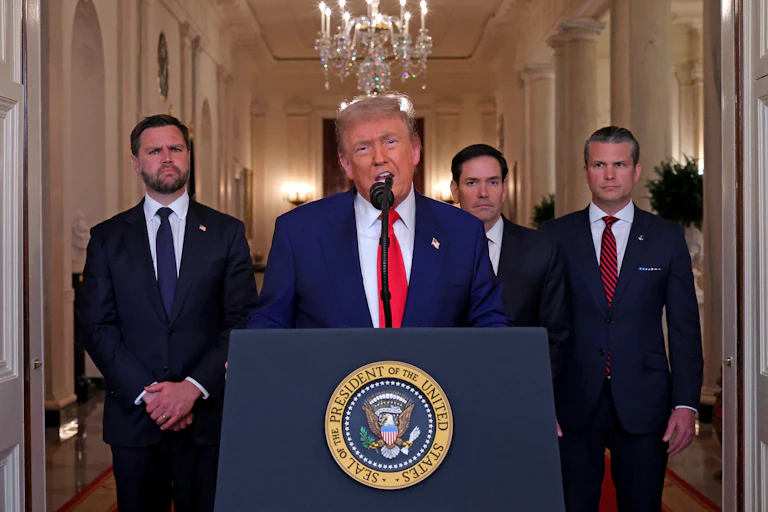 Four men in suits stand at a podium.