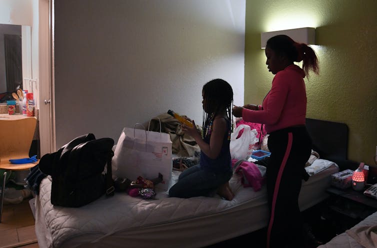 Two people in a cluttered room.What if universal rental assistance were implemented to deal with the housing crisis?