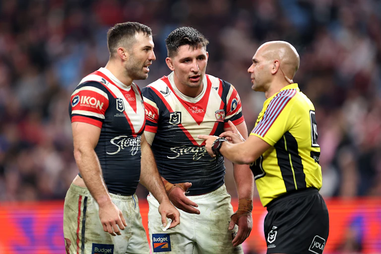 James Tedesco and Victor Radley of the Roosters speak with referee Ashley Klein during a game.