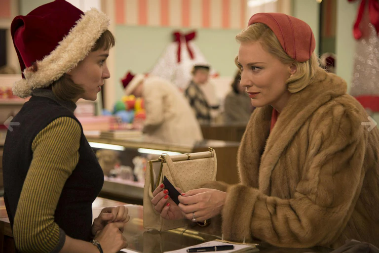 Fotograma de la película. Las dos actrices protagonistas, vestidas al estilo de los años 50, se miran en unos grandes almacenes