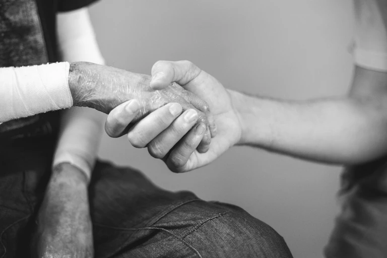 Una mano coge otra afectada por lesiones cutáneas