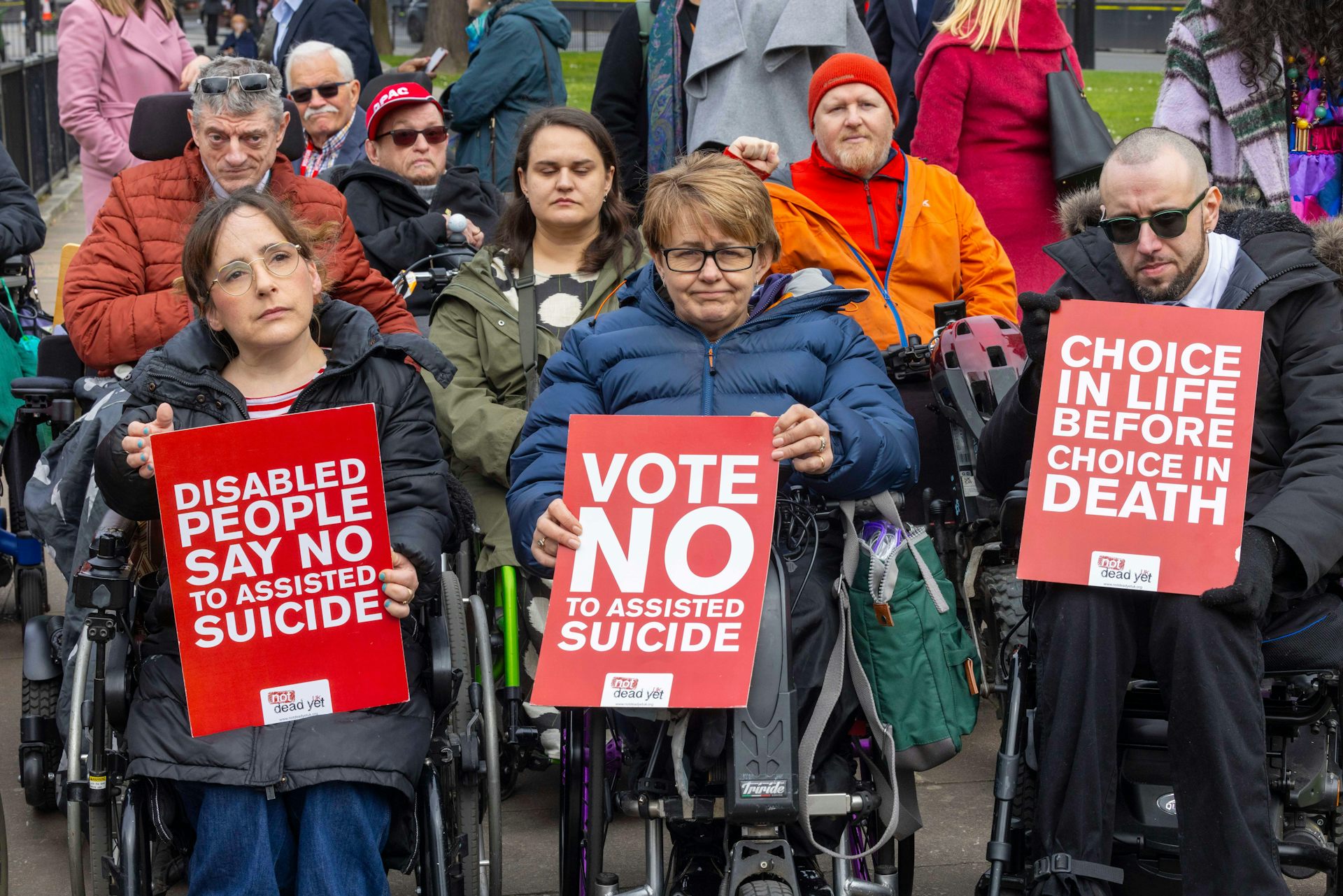 Tanni Grey-Thompson with campaigners, holding a sign reading 'Vote no to assisted suicide'.