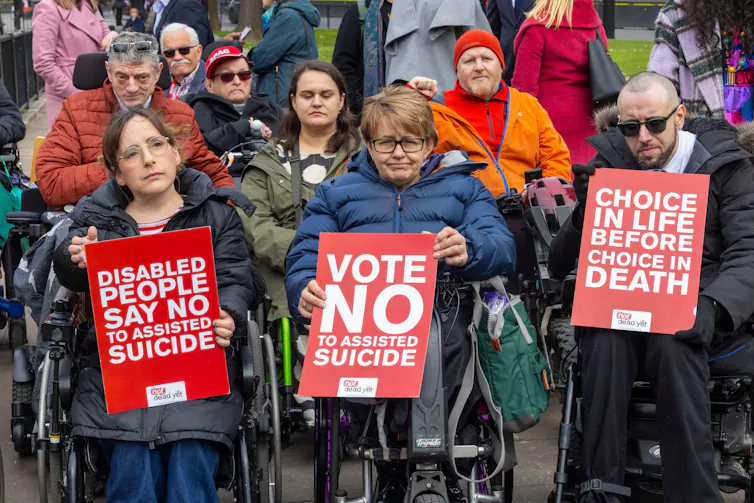 Tanni Grey-Thompson with campaigners, holding a sign reading 'Vote no to assisted suicide'.