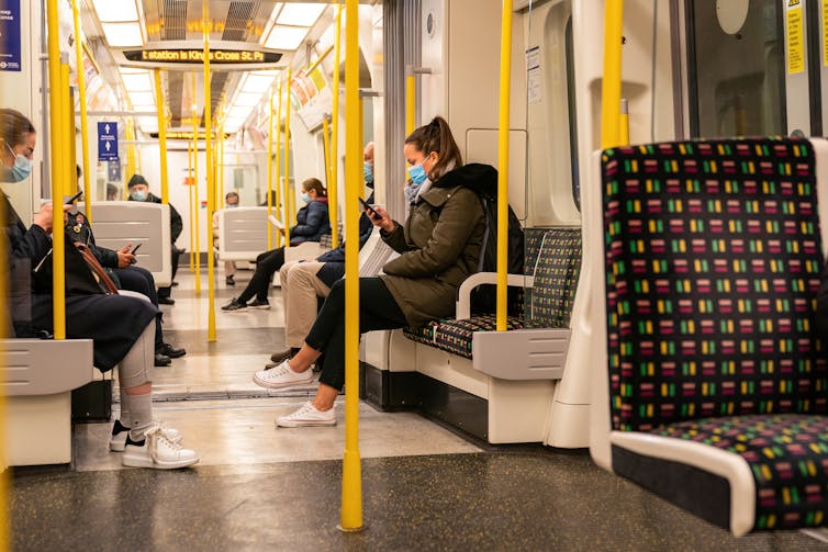 A London Underground train carriage during peak pandemic, with everyone wearing masks.