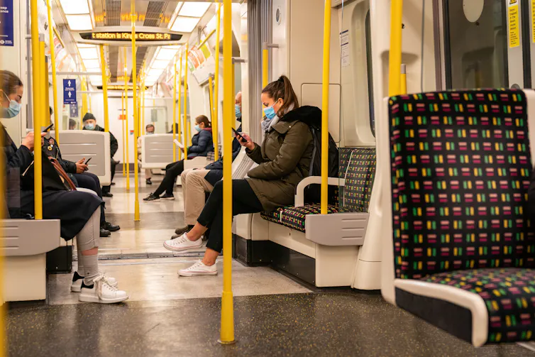 A London Underground train carriage during peak pandemic, with everyone wearing masks.