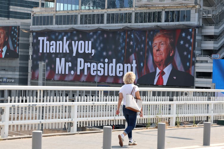 How would possibly the US-Iran warfare escalate? Knowledgeable Q&A 1 A woman walks past a billboard in Tel Aviv saying: 'Thank you Mr President'.