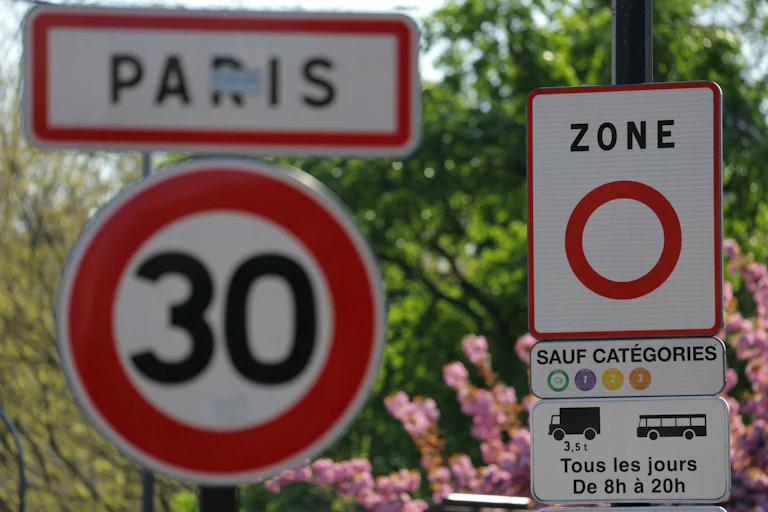 Un panneau (R) de zone à faibles émissions (ZFE) indique où les véhicules à faibles et zéro émissions classés Crit'Air 1, Crit'Air 2 et Crit'Air 3 sont autorisés à circuler, à Paris, le 5 avril 2025. Alors que la droite et le Rassemblement national (RN) à l'Assemblée nationale envisagent de supprimer les zones à faibles émissions (ZFE) dans le cadre du projet de loi de simplification, le gouvernement va proposer le maintien d'une obligation minimale pour les agglomérations parisienne et lyonnaise. (Photo de Thomas SAMSON / AFP)