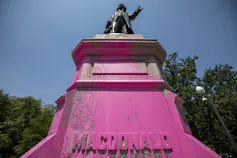 The base of a statue covered in pink paint.