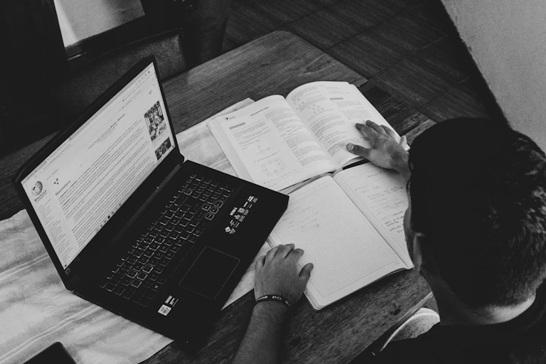 étudiant comparent livres et ordinateur