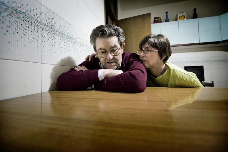 A couple sitting at a kitchen table.