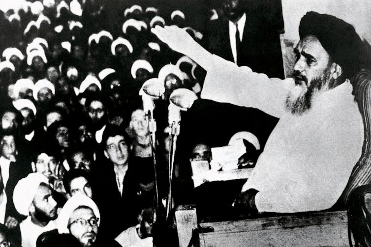 Iran’s historical past has been blighted by means of interference from overseas powers 3 A middle-aged man with a beard in traditional Islamic clothing gestures to a crowd as he makes a speech.