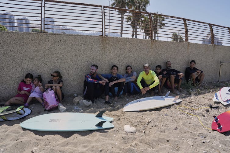 ¿Cómo es la crisis doméstica israelí y el proyecto del proyecto Netanyahu apuntan cerca del este? 5 Los surfistas con tablas de surf se encuentran en una fijación de concreto en la playa.