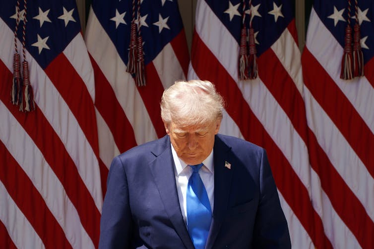 Donald Trump stood in front of a US flag.