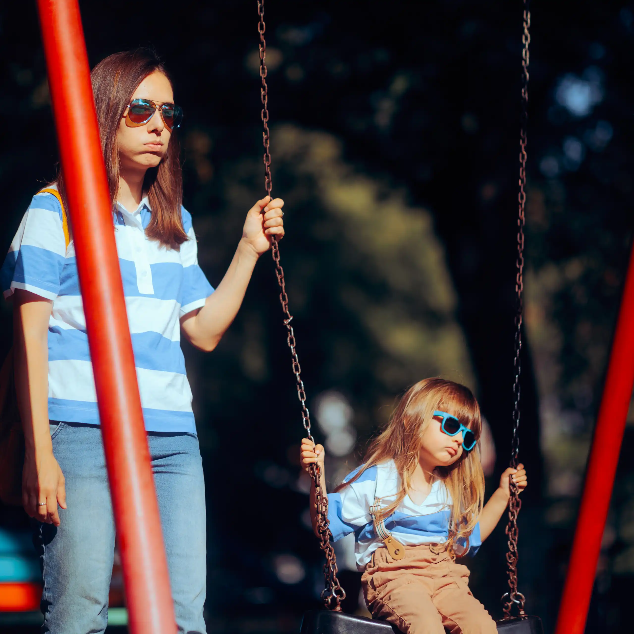 Madre e hija aburridas en un parque infantil