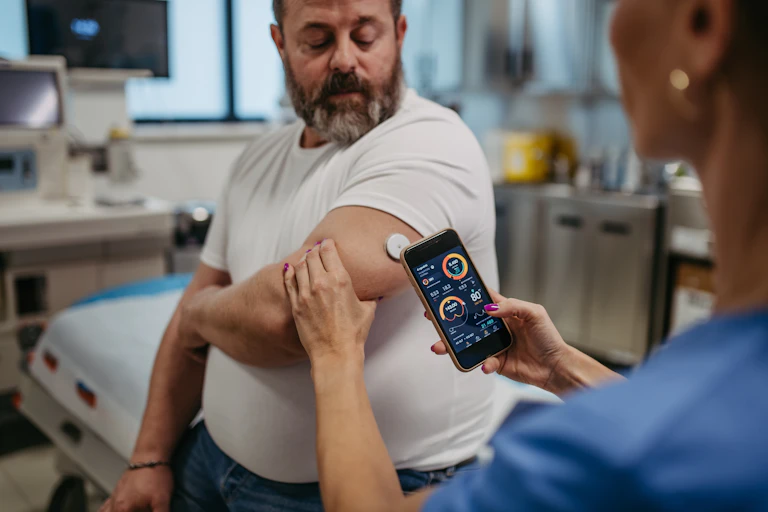 A man having his continuous glucose monitor checked by his doctor.
