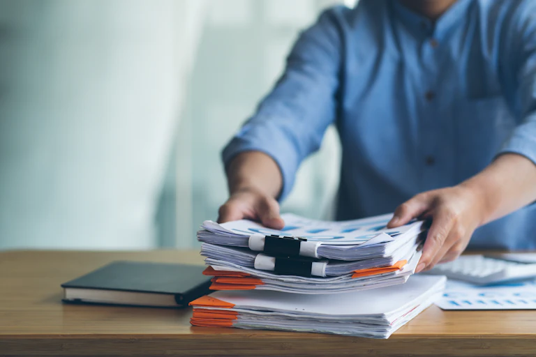 Businessman Preparing reports papers with graphs, charts on Stacks of documents files for finance in office.