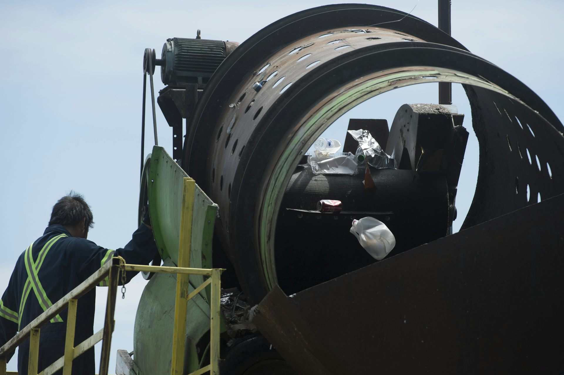 El hombre de pie al lado de la máquina que parece un tubo grande