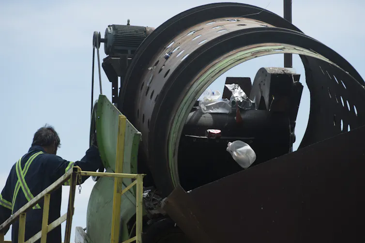 a man standing next to a machine that looks like a large tube