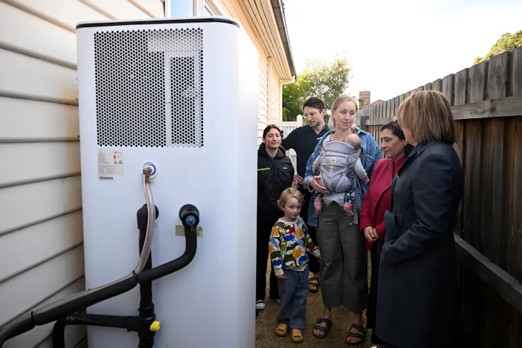 people looking at a heat pump.