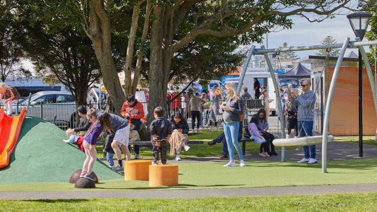 Children playing in a fenced playground in New Zealand.