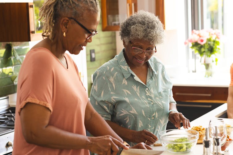 Two women preparing food in a kitchen
