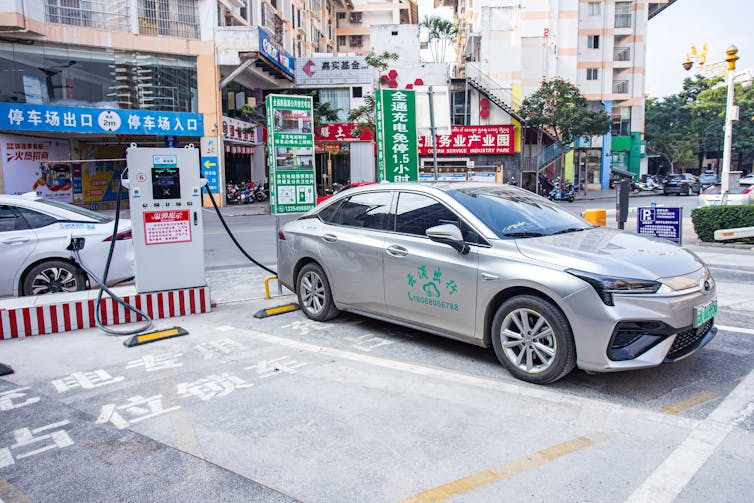 Electric car being charged on Chinese street.