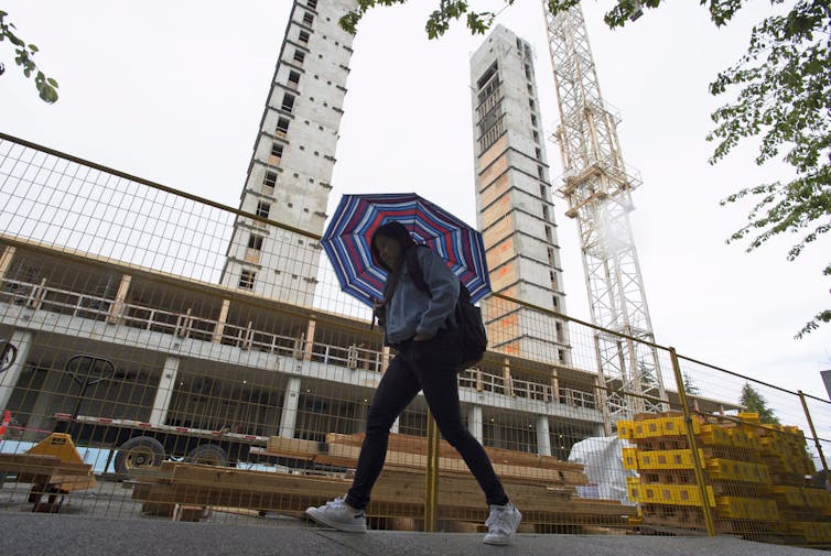 Los líderes universitarios deben tener sentido para los trastornos enormes: 4 formas en que lo hacen 1 La persona con un paraguas pasa el sitio de construcción.