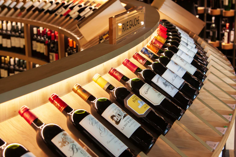 A curved row of bottles of wine on display in a wine shop.