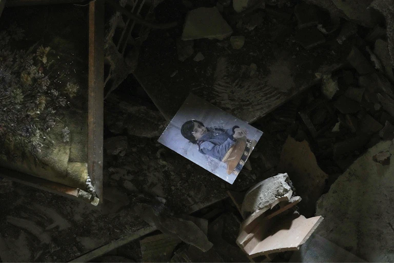 A photo of a child lies in rubble.