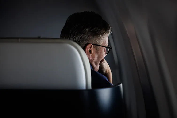Keir Starmer looking out of an aeroplane window.