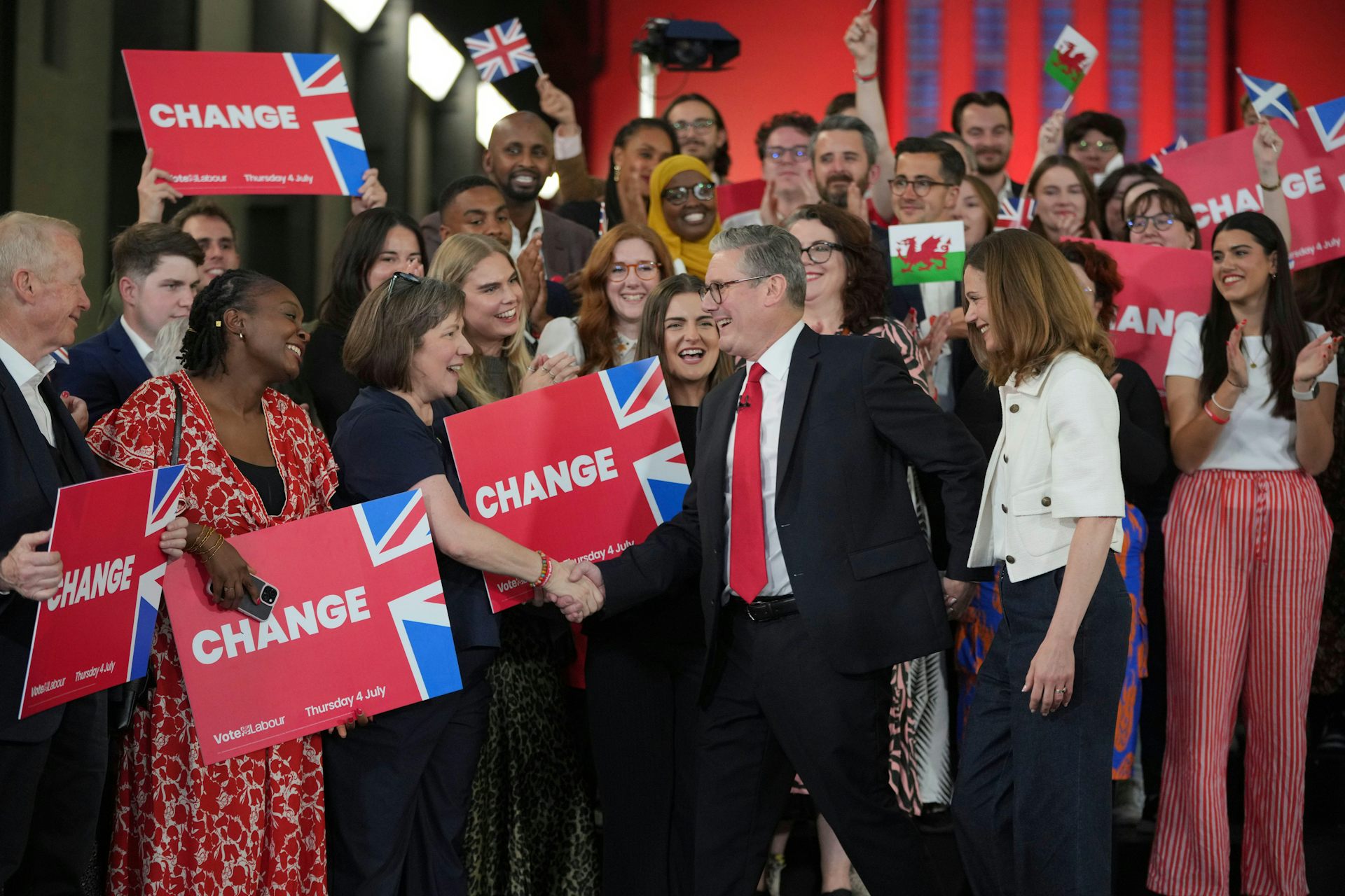Keir Starmer and his wife greeting supporters holding signs reading 'change'.