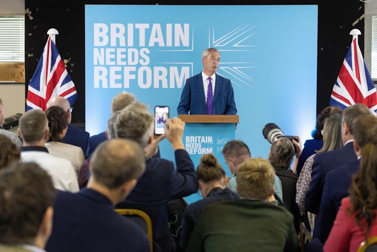 Survey displays beef up for electoral reform now at 60% – so may it occur? 1 Nigel Farage giving a speech in front of a sign reading 'Britain needs Reform'.