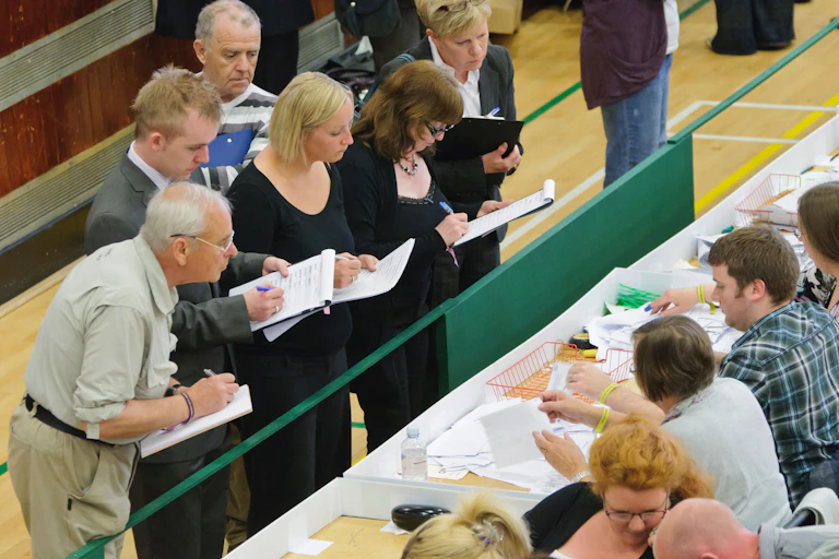 Election officials monitoring a vote count.