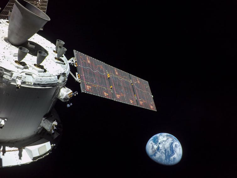 Earth in outer space with part of a spacecraft seen off to the side