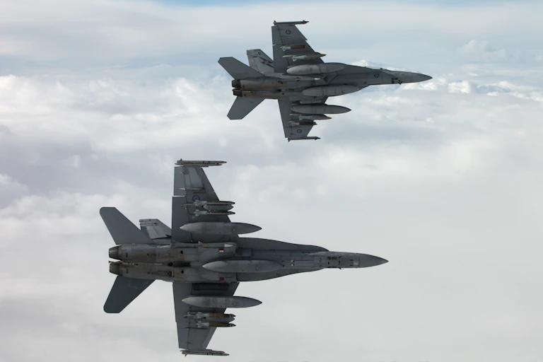 Two jets fly through the sky
