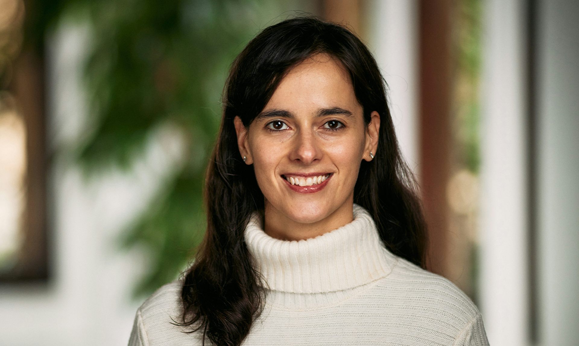 Carissa Veliz mira a cámara con un jersey beis.