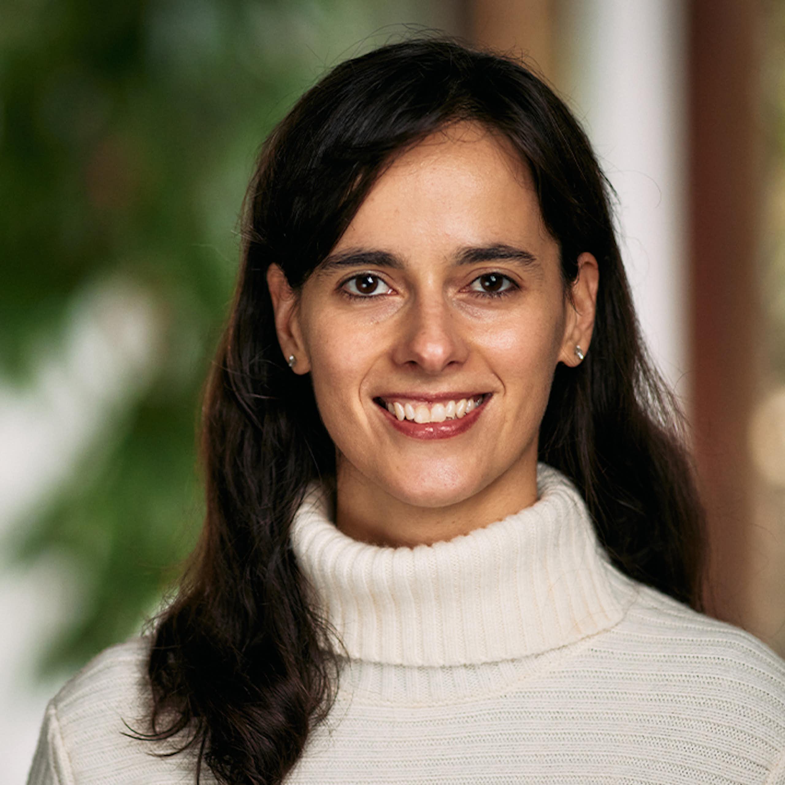 Carissa Veliz mira a cámara con un jersey beis.