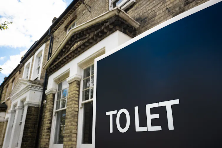 A blue To Let sign outside of a terraced house