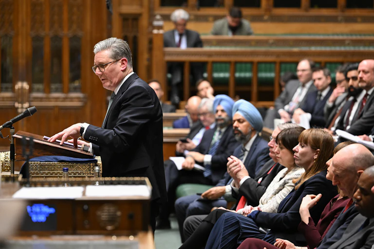 Keir Starmer speaking in parliament with MPs sitting behind him.